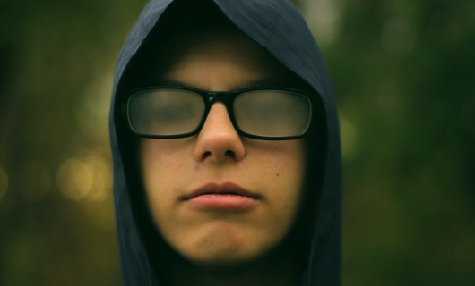 Ein Junge mit beschlagener Brille und Kapuze auf dem Kopf.