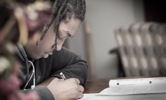 Ein junger Mann macht Hausaufgaben.